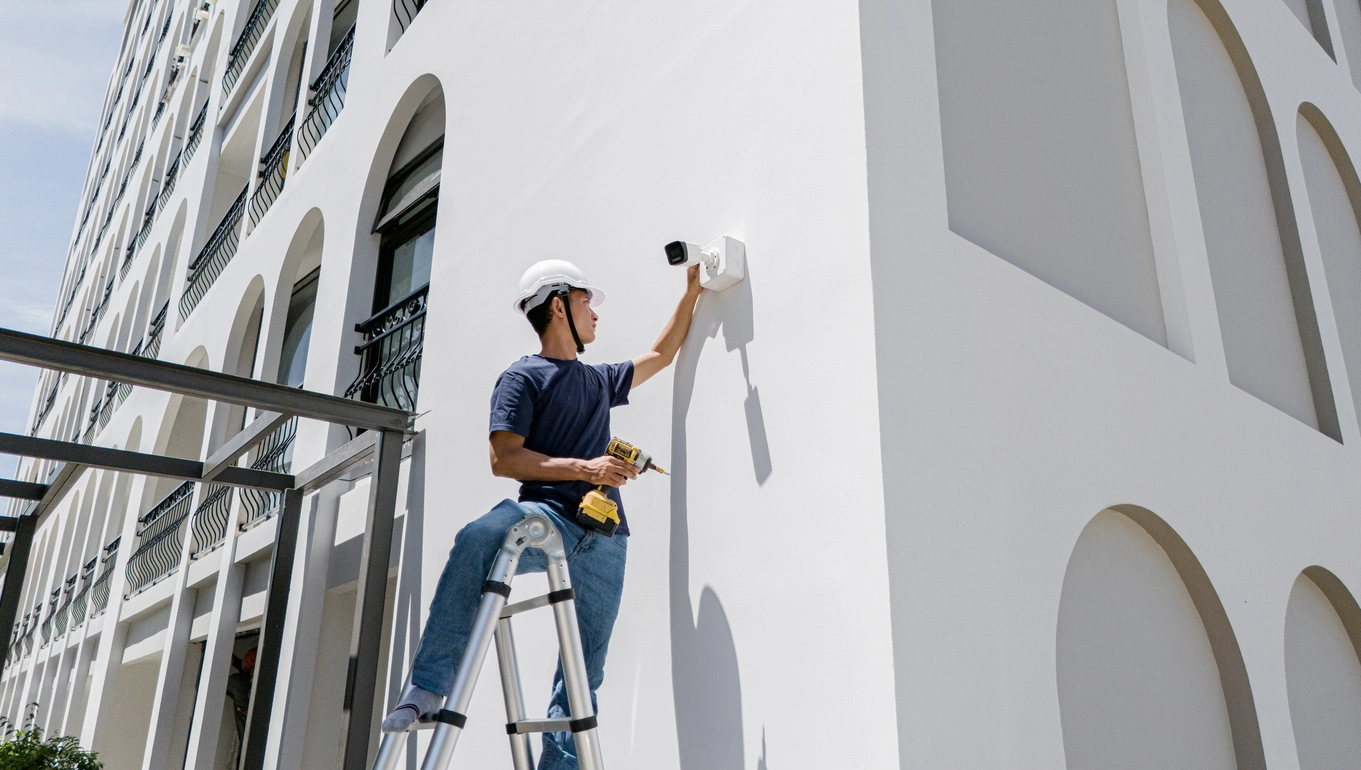 Technician installing commercial security camera on building in Columbus Ohio