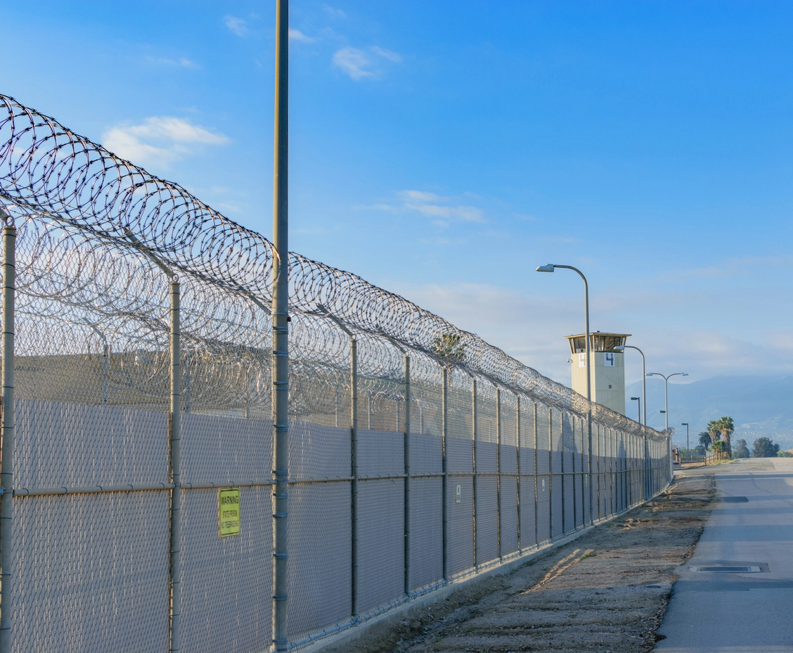 outdoor security camera monitoring correctional facility perimeter fence