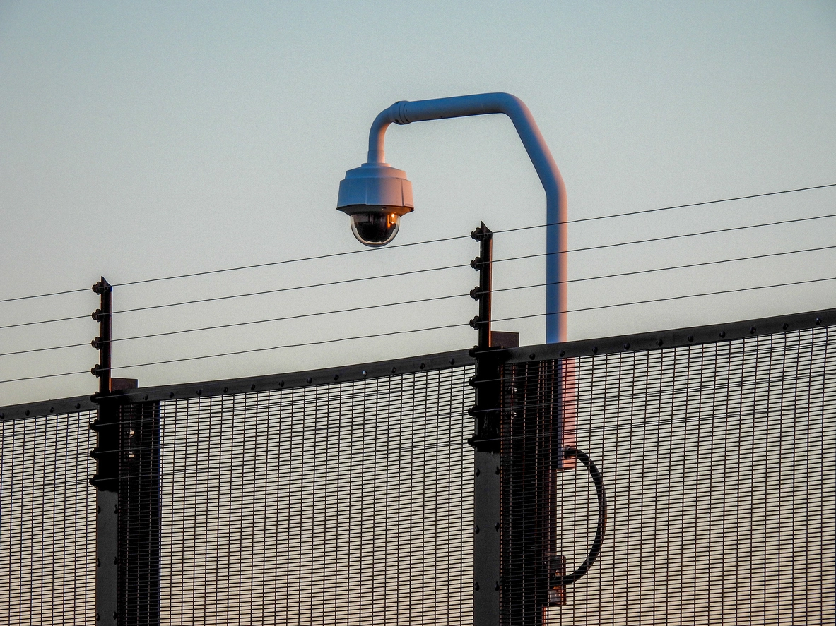 outdoor security camera monitoring fenced perimeter of water treatment plant